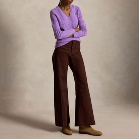 Model wearing Polo Ralph Lauren knitwear in Amethyst Falls Heather, cable-knit V-neck sweater, styled with wide-leg brown trousers.