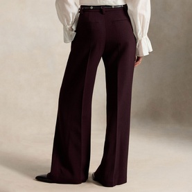 Model wearing Polo Ralph Lauren Midnight Merlot wide-leg trousers, rear view, styled with a white ruffled blouse and dark belt.