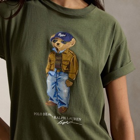 Model wearing Polo Ralph Lauren Dense Olive T-Shirt featuring Polo Bear graphic in jacket, jeans and cap print