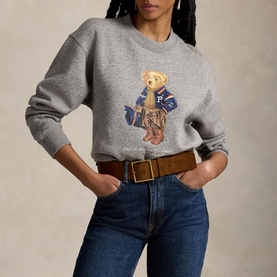 Model wearing Polo Ralph Lauren Dark Vintage Heather sweat top with Polo Bear graphic, styled with dark jeans and brown belt.