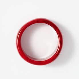 Mint Velvet red resin bangle bracelet, circular silhouette with glossy finish, shot from above