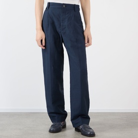 Model wearing Jacquemus dark navy casual trousers with wide-leg fit and button waistband, styled with dark loafers.