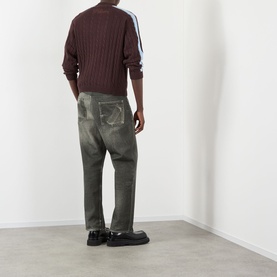 Model wearing Pellador Overlap Cable Knit Sweater in brown with double-stripe sleeve detail, styled with khaki trousers and black loafers.