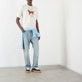 Model wearing Pellador Red Setter Logo T-Shirt in white with light blue jeans and a blue shirt tied at the waist.