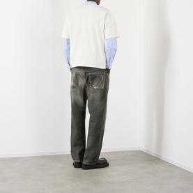 Model wearing Pellador Swan Logo T-Shirt in white, styled with a blue shirt, dark olive trousers and black shoes, shot from behind.