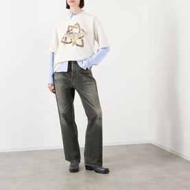 Model wearing Pellador Swan Logo T-Shirt in white with blue shirt underneath, styled with dark olive wide-leg jeans and black loafers.
