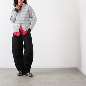 Model wearing Pellador grey striped cotton zip-through knit jacket with black wide-leg trousers and pink shirt underneath.