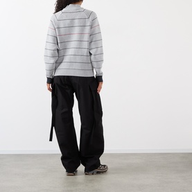 Model wearing Pellador grey striped cotton zip through knit, styled with black wide-leg cargo trousers, back view
