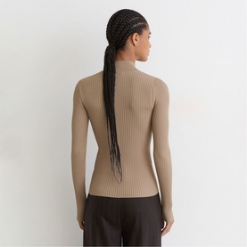 Model wearing Reiss beige ribbed roll-neck jumper, long sleeves, fitted silhouette, styled with dark wide-leg trousers. Back view.