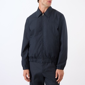 Model wearing A.P.C. dark navy cotton casual jacket with zip front, elasticated cuffs and hem, styled with matching trousers
