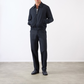 Model wearing A.P.C. dark navy cotton casual jacket with zip collar, styled with matching navy trousers and black leather shoes.
