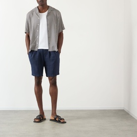 Model wearing A.P.C. Bennet Printed Shirt in dark navy, styled with navy shorts and black leather sandals.