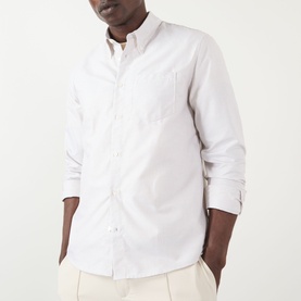 Model wearing A.P.C. beige cotton casual shirt with button-down collar and chest pocket, styled with cream trousers