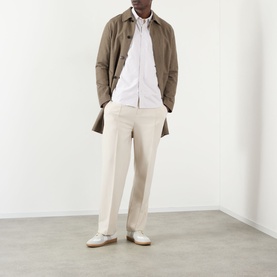 Model wearing A.P.C. beige cotton casual shirt, styled with a brown overcoat and cream tailored trousers
