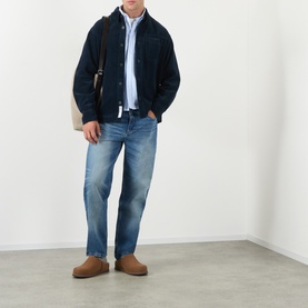 Model wearing A.P.C. Patch Pocket Corduroy Shirt in dark navy, styled with light blue shirt, mid-wash jeans and tan suede boots