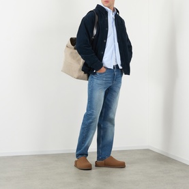 Model wearing A.P.C. Patch Pocket Corduroy Shirt in dark navy over light blue shirt, styled with mid-wash jeans and tan suede loafers