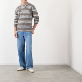 Model wearing A.P.C. grey striped mohair-alpaca crew neck jumper with wide-leg light blue jeans and white trainers.