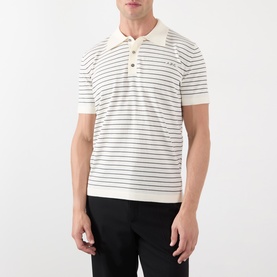 Model wearing A.P.C. natural stripe cotton polo shirt with short sleeves and button placket, styled with black trousers.