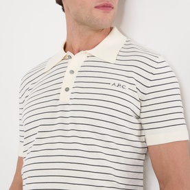 Model wearing A.P.C. polo shirt in natural, featuring dark narrow stripes, ribbed collar, and short sleeves with embroidered logo