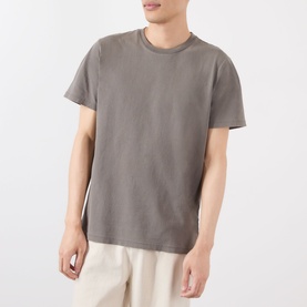 Model wearing grey crew neck short sleeve T-shirt, styled with cream trousers