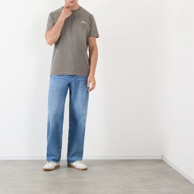 Model wearing A.P.C. GRIS TAHITI cotton polo shirt with light blue straight-leg jeans and white trainers.