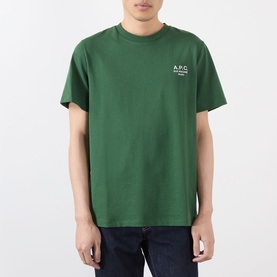 Model wearing A.P.C. dark green cotton T-shirt with small white chest logo print, styled with navy jeans.