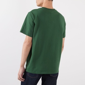Model wearing A.P.C. dark green cotton T-shirt, rear view, styled with dark denim jeans.