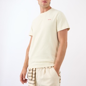 Model wearing A.P.C. Oliver Logo T-Shirt in white, round neck with small red logo, styled with checked shorts.