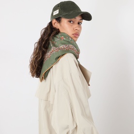 Model with Max Mara Weekend Rago Corduroy Cap in green, styled with a floral scarf and beige jacket.