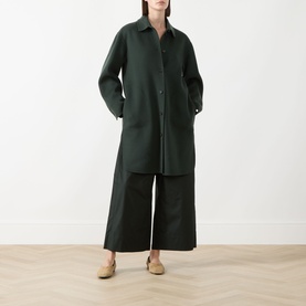 Model wearing Max Mara S emerald wool coat, midi length with front pockets, styled with wide-leg trousers and nude mules.