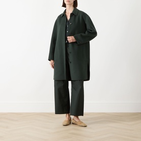 Model wearing Max Mara S emerald wool coat, styled with matching trousers, dark shirt, and beige flat mules