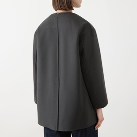 Model wearing Max Mara S dark grey 100% virgin wool coat, rear view, showing collarless design and centre back seam detail.