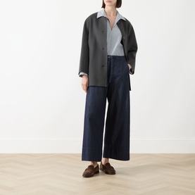 Model wearing Max Mara S dark grey virgin wool coat, styled with light grey shirt, wide-leg navy jeans and brown loafers.