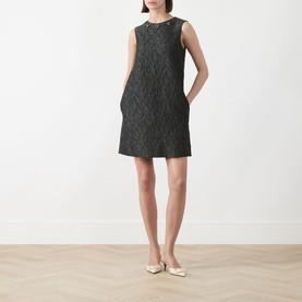 Model wearing Max Mara S Vicolo Jacquard Mini Shift Dress in dark green, sleeveless with crew neck and textured pattern, styled with cream flat shoes