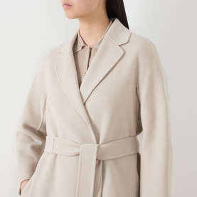 Model wearing Max Mara S Esturia Belted Wrap Coat in beige, featuring notched lapels and self-fabric belt, styled with a collared shirt underneath.