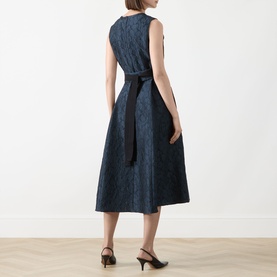 Model wearing Max Mara S midnight blue jacquard midi dress, sleeveless with tie belt, shown from back, styled with black heeled mules.