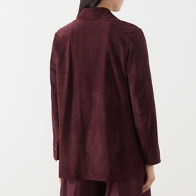 Model wearing Max Mara S Gocce Suede Jacket in red, shown from behind, with shirt collar, long sleeves, and square back slits. Styled with matching
