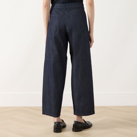 Model wearing Max Mara S Midnight Blue wide-leg jeans, rear view, styled with black loafers.