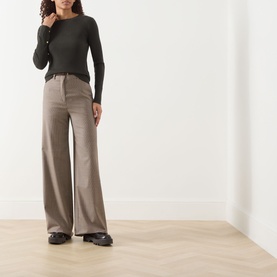 Model wearing Max Mara S Disegno Ribbed-Knit Sweater in kaki with long sleeves, boat neck and cuff buttons, styled with wide-leg trousers.