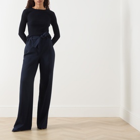 Model wearing Max Mara S Disegno Ribbed-Knit Sweater in ultramarine with boat neck and long sleeves, styled with wide-leg navy trousers.