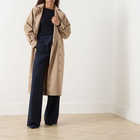 Model wearing Max Mara S Disegno Ultramarine ribbed-knit sweater with boat neck, styled with a camel longline coat and navy wide-leg trousers.