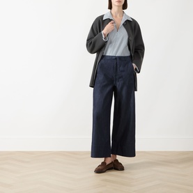 Model wearing Max Mara S Jour Wide-Leg Joggers in Midnight Blue, styled with a grey jacket, light blue top and brown loafers.