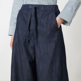 Model wearing Max Mara S Jour Wide-Leg Joggers in Midnight Blue denim with drawstring waist, styled with a blue striped shirt.