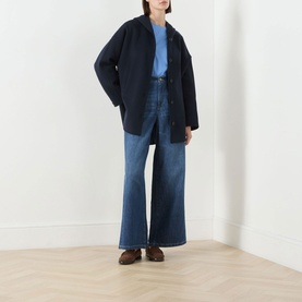 Model wearing Max Mara S China Blue wide-leg jeans, styled with a navy oversized jacket, light blue top, and brown loafers.