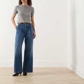 Model wearing Max Mara S Giulietta Light Grey slim fit sweater with short sleeves, styled with wide-leg blue jeans and black heels.