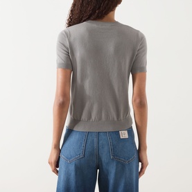 Model wearing Max Mara S Giulietta Slim Fit Sweater in light grey, short sleeves, round neck, ribbed trims. Styled with blue wide-leg jeans.