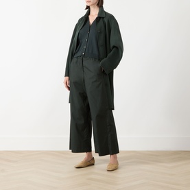 Model wearing Max Mara S Saggio Knitted Vest in green, styled with matching wide-leg trousers, a dark shirt, and beige loafers.