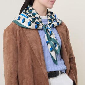Model with Max Mara Weekend Onesto Silk Printed Scarf in dark green, geometric print, worn loosely over a blue knit and tan suede jacket