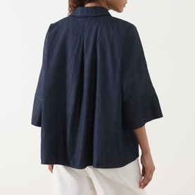 Model wearing Max Mara S Rugiada Chambray Boxy Shirt in Midnight Blue, back view, with cropped sleeves and boxy fit, styled with white trousers.