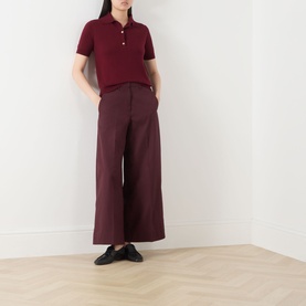 Model wearing Max Mara S red cotton silk cashmere knit polo shirt, styled with wide-leg dark trousers and black loafers.